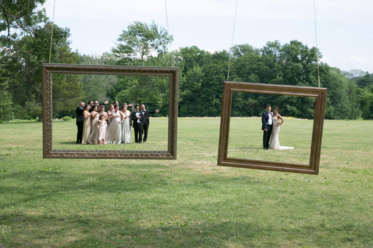 A couple and their wedding party framed inside suspended picture frames