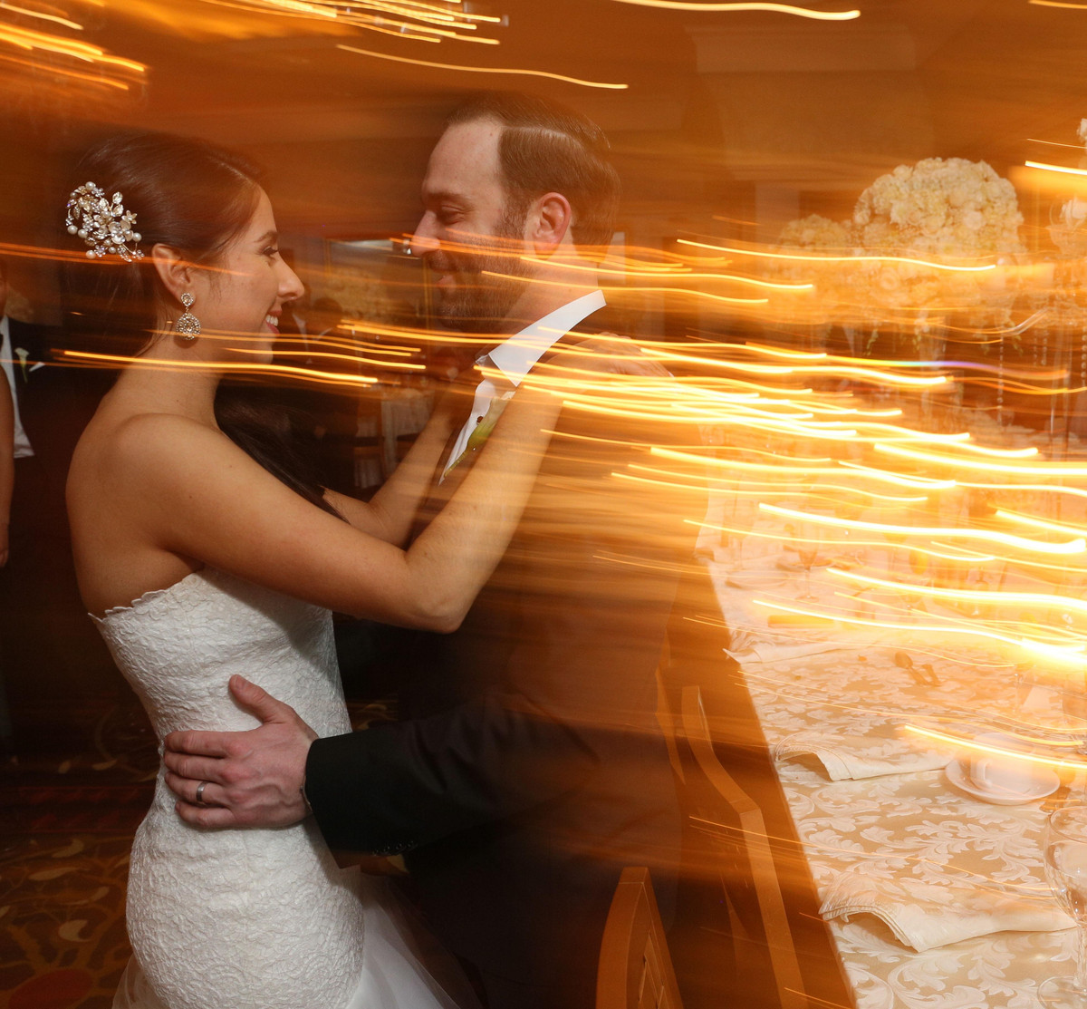 A newlywed couple surrounded by warm streaks of light